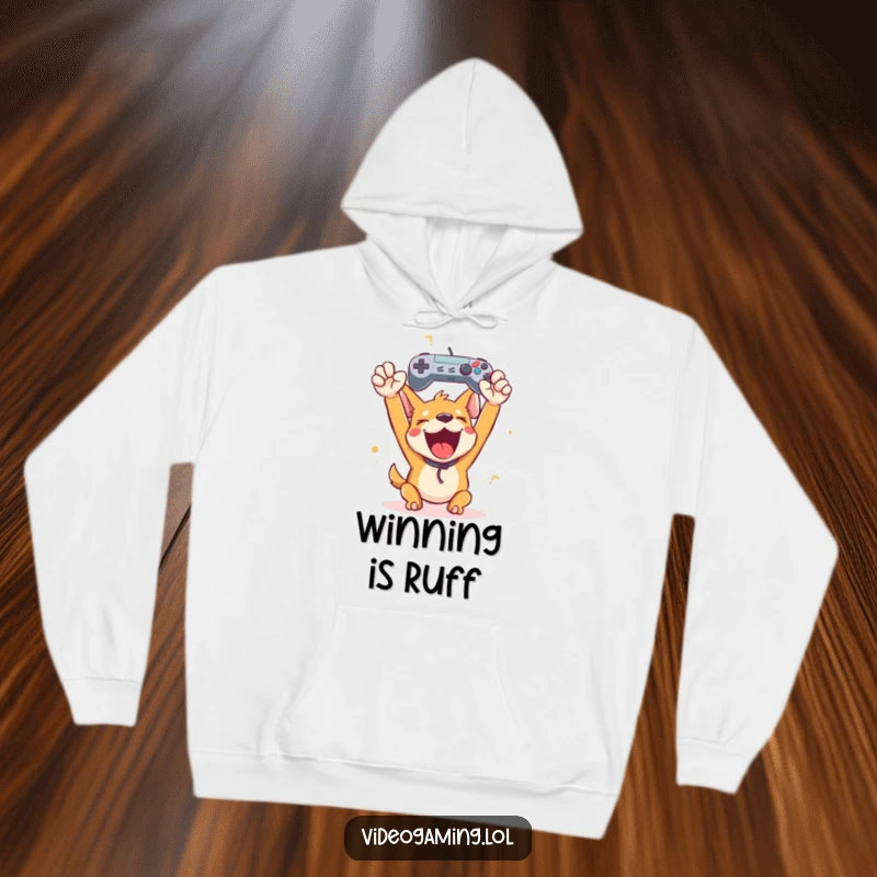 Funny happy dog cheering with a game controller aloft, featured on a cozy hoodie for humorous gaming victory celebrations.